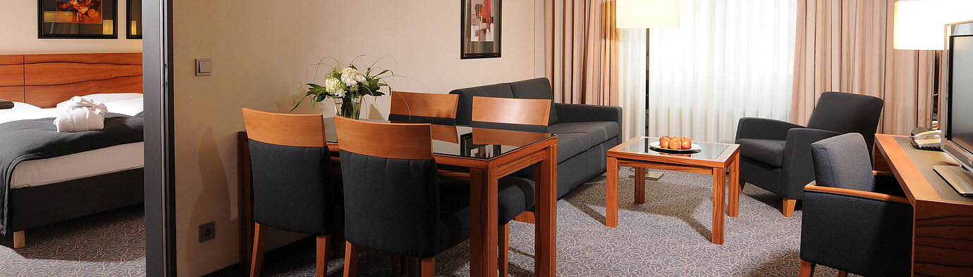 Suite spacieuse avec salon, table à manger et chambre séparée à l’hôtel Maritim Munich