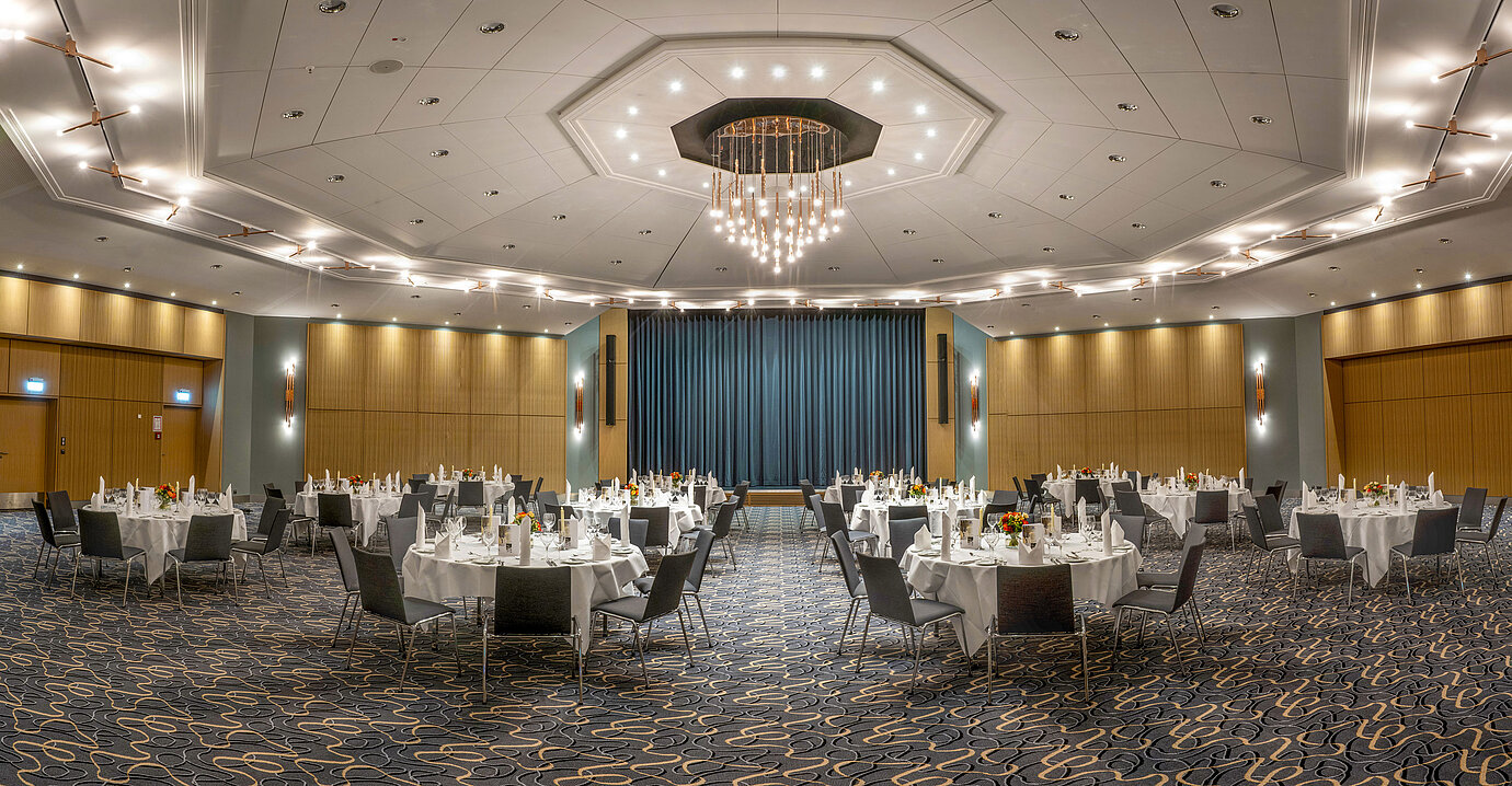 Gran salón de banquetes Barbarossa en el Maritim Hotel Würzburg con mesas redondas y ambiente elegante.