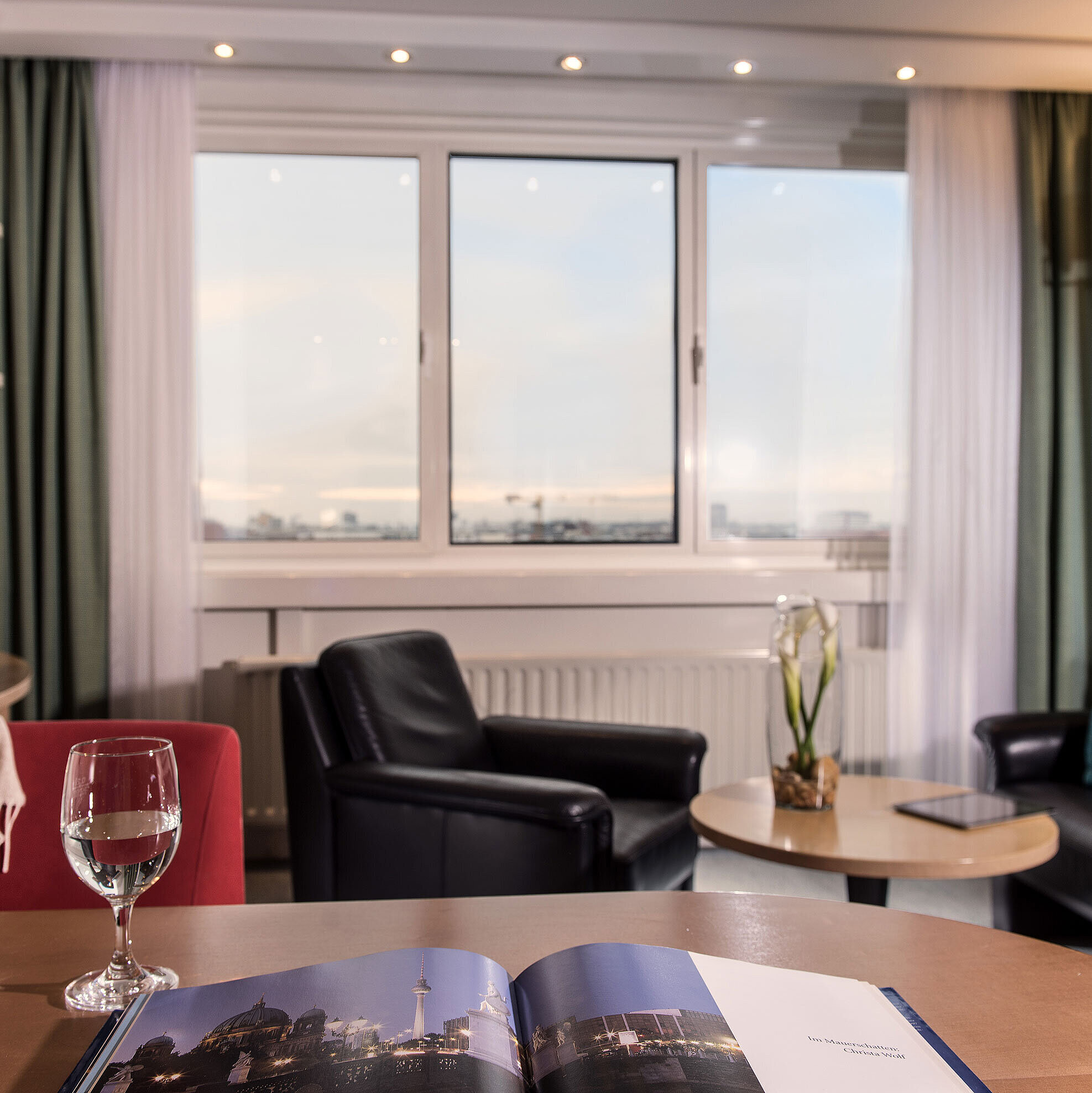 Junior Suite en Maritim proArte Hotel Berlín con área de estar, vista a la ciudad y detalles de diseño elegante.