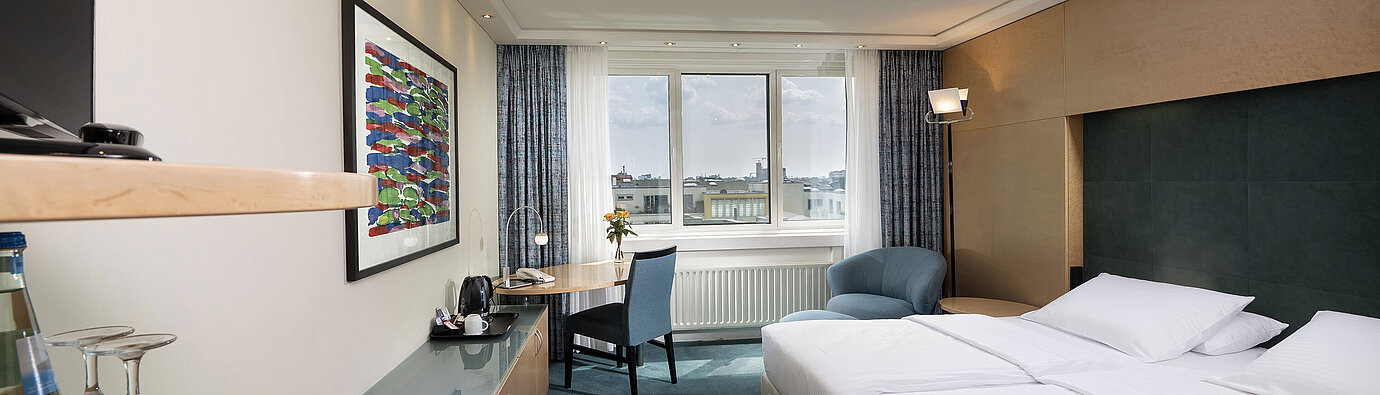 Comfort room with double bed, desk and cosy seating area at Maritim proArte Hotel Berlin