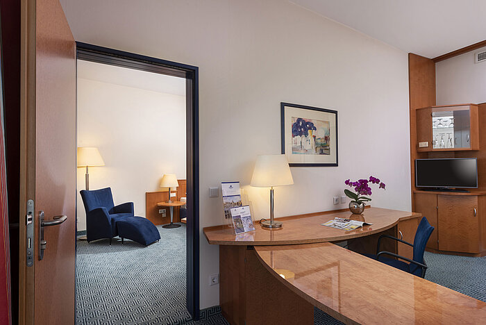 Camera familiare Comfort del Maritim Hotel Frankfurt con zona giorno e notte separate, scrivania e arredo elegante.