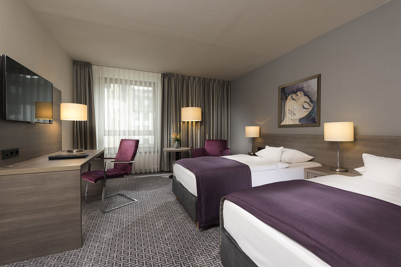 Chambre double moderne de l'hôtel Maritim Königswinter avec deux lits, bureau et décoration élégante.