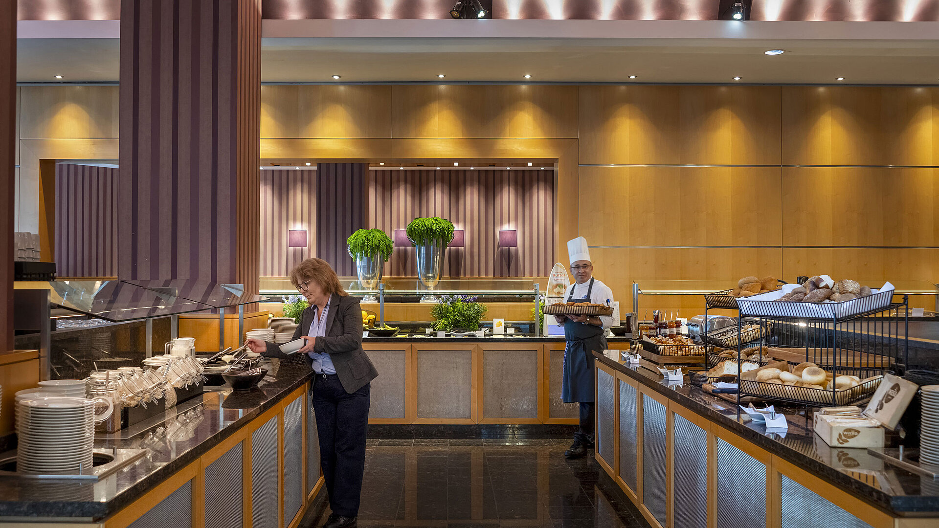 Buffet petit-déjeuner à l'hôtel Maritim Düsseldorf avec pain frais, plats chauds et un chef servant les clients.