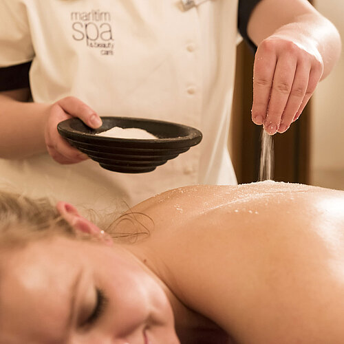 Gros plan d’un traitement au sel sur le dos au spa du Maritim Seehotel Timmendorfer Strand.