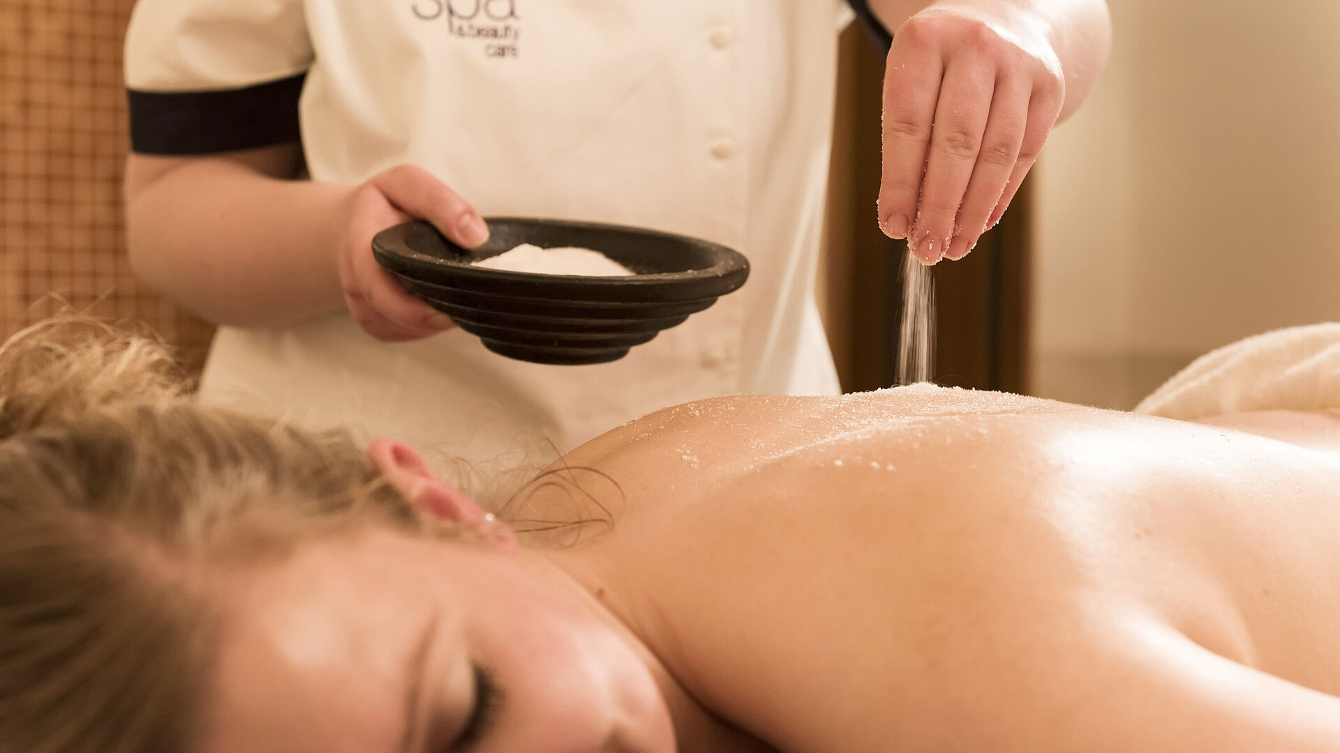 Gros plan d’un traitement au sel sur le dos au spa du Maritim Seehotel Timmendorfer Strand.