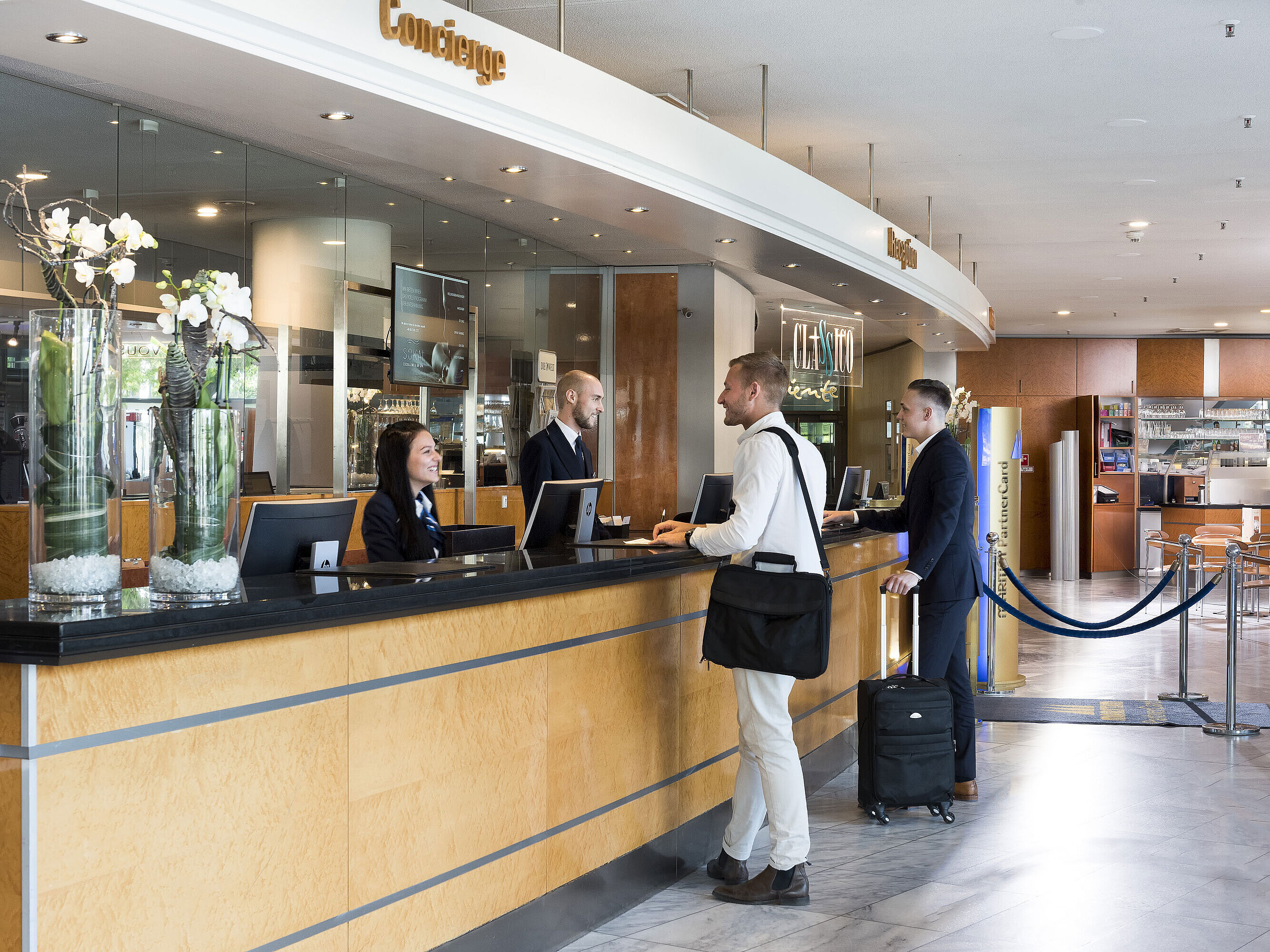 Accueil chaleureux à la réception de l'hôtel Maritim Frankfurt avec clients et personnel dans un hall moderne.