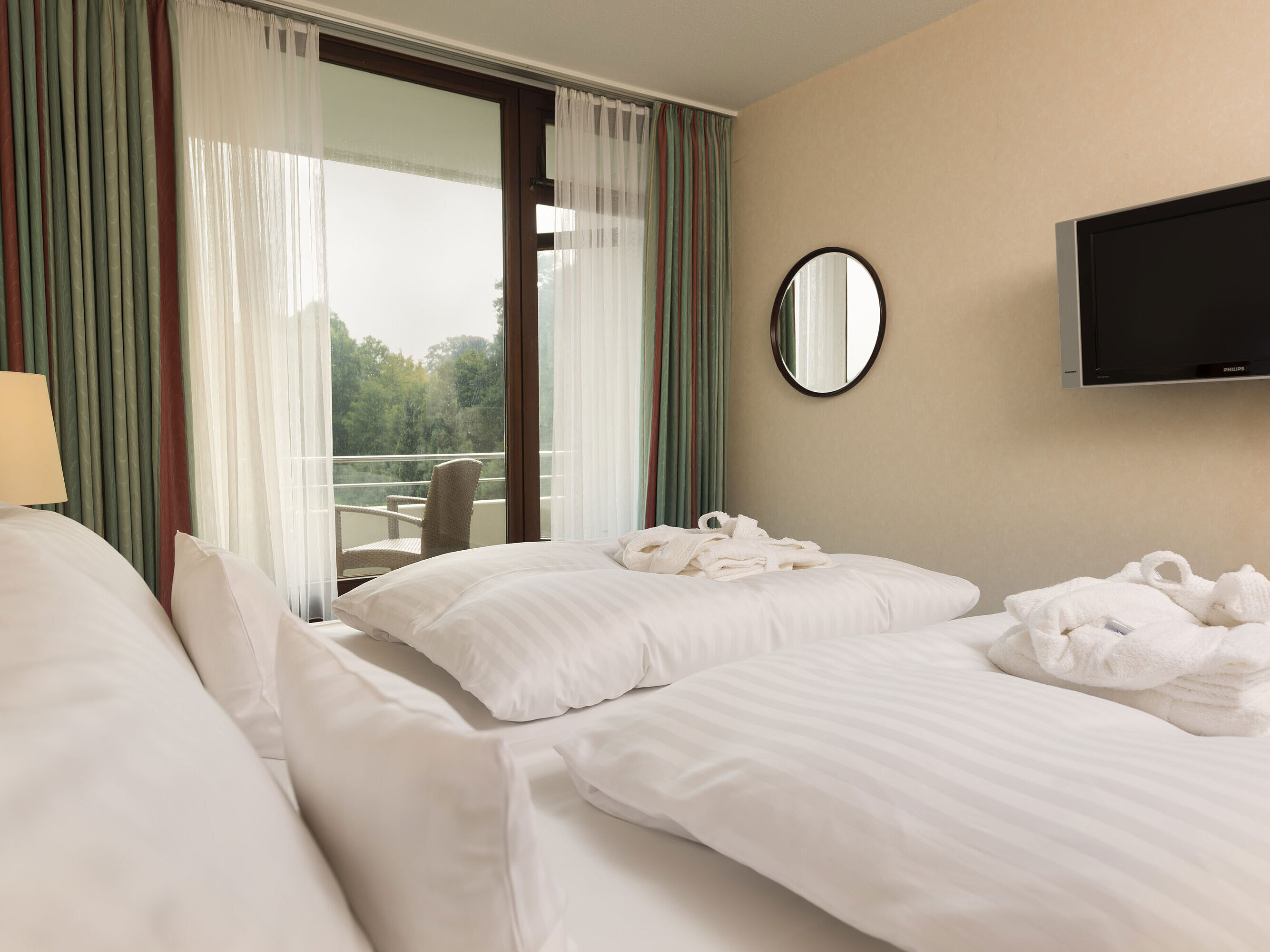 Suite Junior Cama doble con TV, albornoz y vista al balcón en el Maritim Hotel Bad Salzuflen