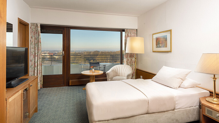 Camera con letto singolo, poltrona e balcone con vista su Travemünde e baia di Lubecca