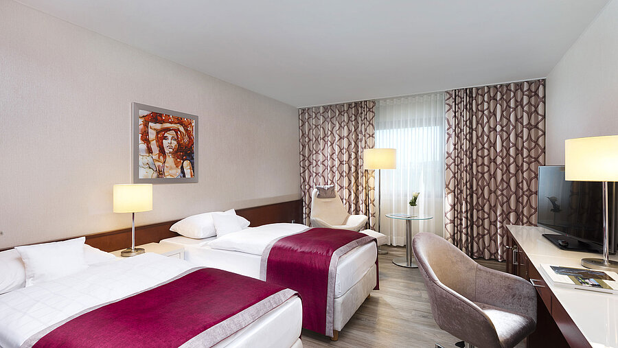 Chambre adaptée aux allergiques à l'hôtel Maritim Bonn avec deux lits simples, bureau, télévision et sol hypoallergénique.