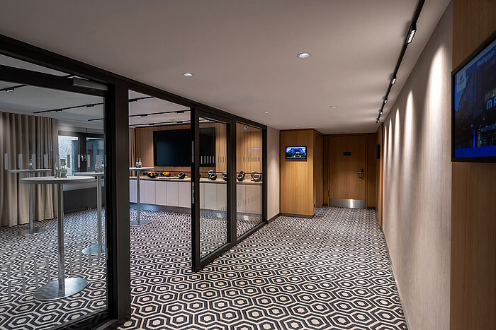 Zona de pausa para café moderna con mesas altas, estación de café y ambiente elegante para reuniones.