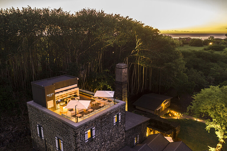 A stylish hotel rooftop terrace with comfortable seating and breathtaking sunset views