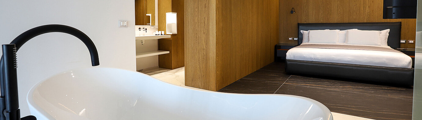 Suite de lujo en Maritim Resort Marina Bay con bañera exenta y dormitorio moderno