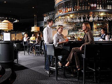 Ospiti che si godono drink e conversazioni al bar elegante del Maritim Hotel Monaco