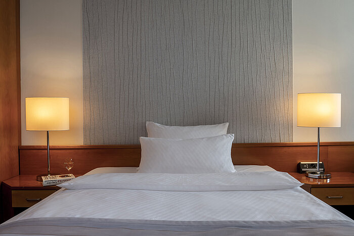 Camera Superior moderna con letto elegante, comodini e illuminazione soffusa al Maritim Hotel Hannover.
