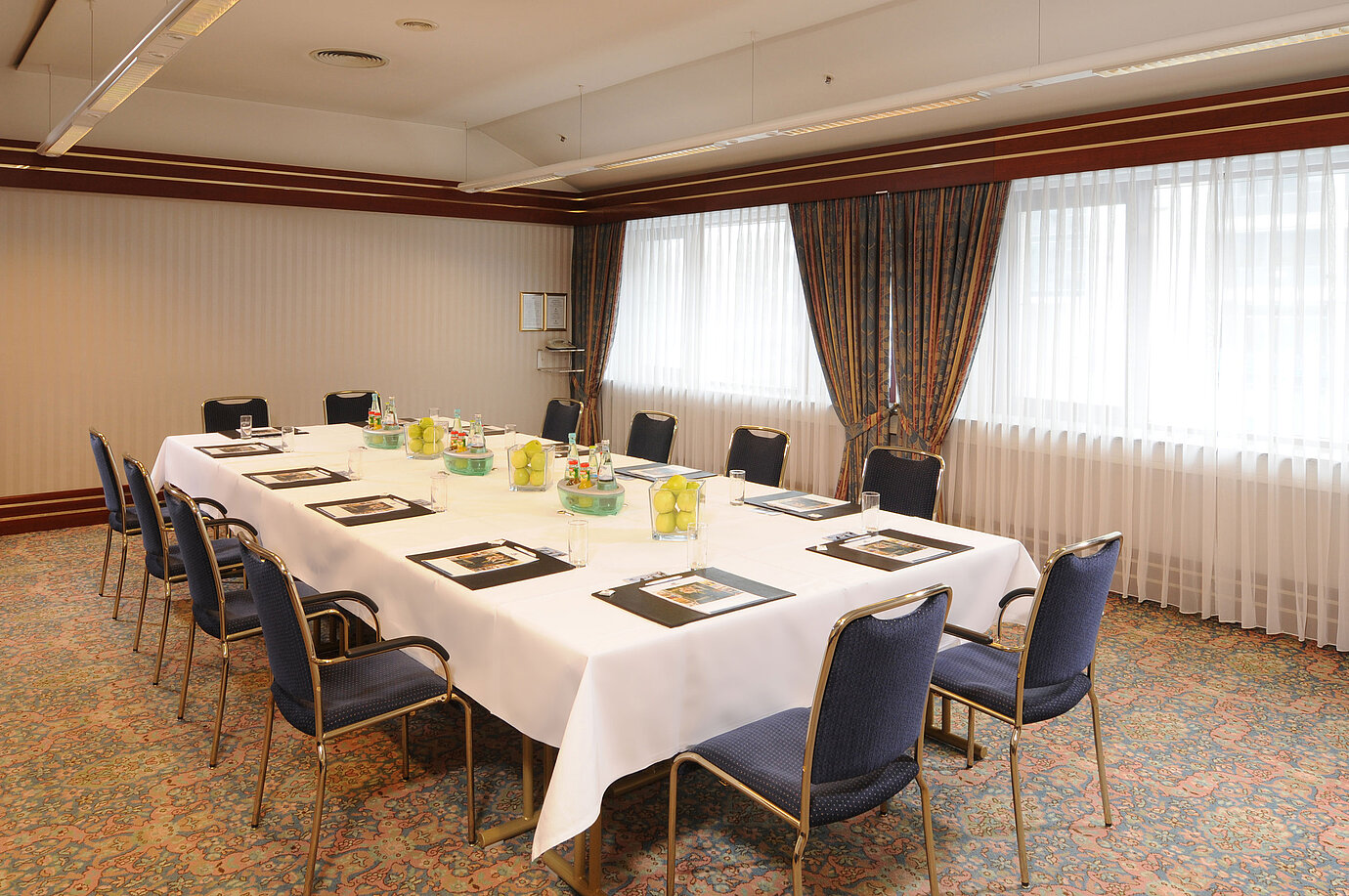 Sala de reuniones luminosa con asientos en U y decoración fresca en el Maritim Hotel Magdeburg.