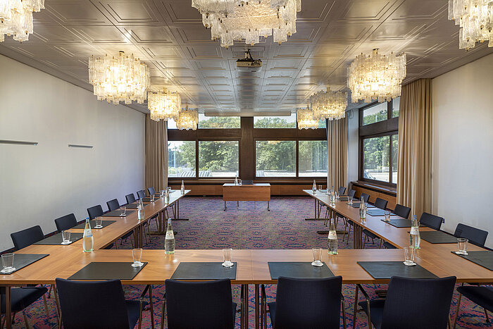 Sala en forma de U con lámparas elegantes y grandes ventanas en el Maritim Hotel Travemünde