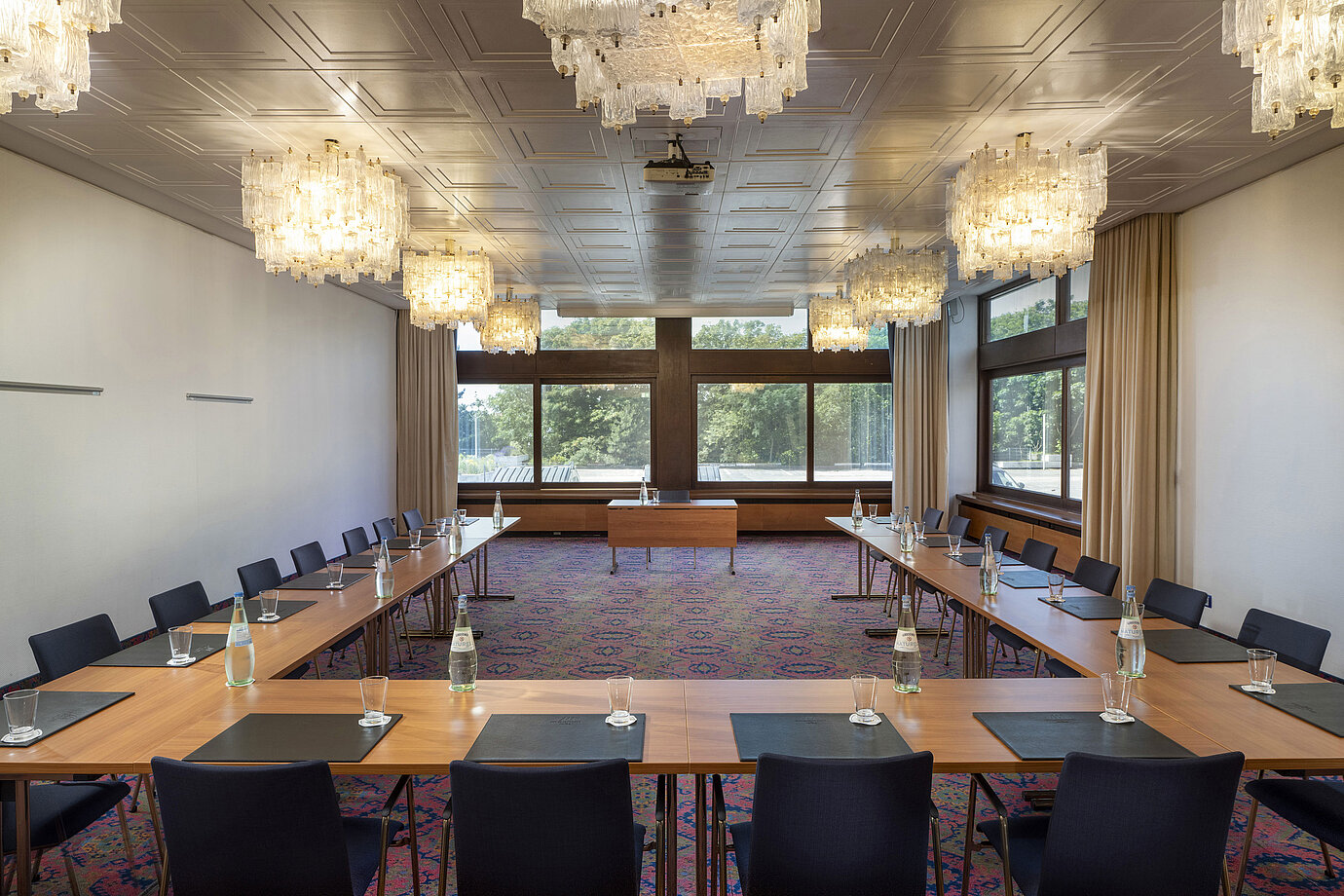 Sala en forma de U con lámparas elegantes y grandes ventanas en el Maritim Hotel Travemünde