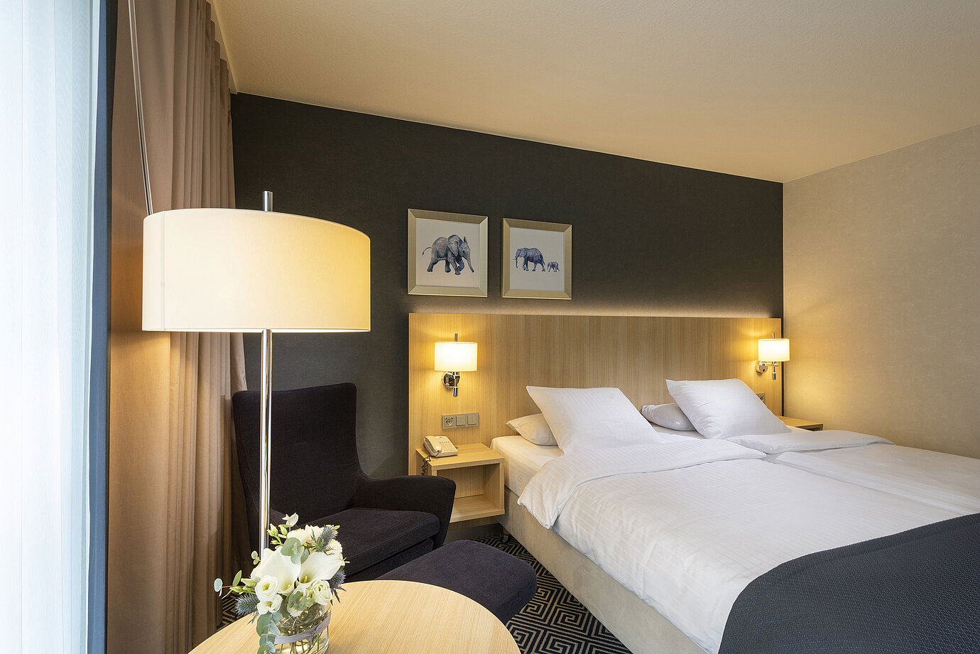 Camera Comfort luminosa al Maritim Hotel Würzburg con letto matrimoniale e quadri di elefanti a parete