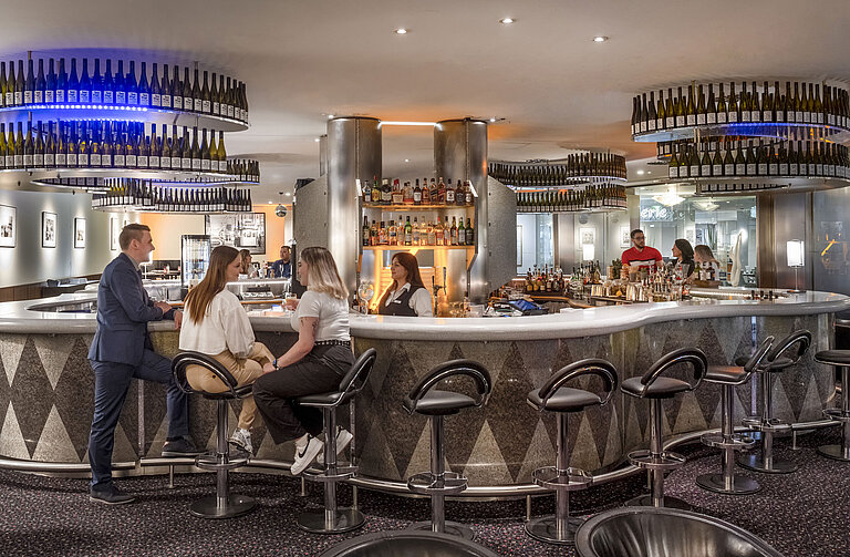 Bar élégante de l'hôtel Maritim proArte où les clients profitent de conversations détendues et d'un large choix de boissons.