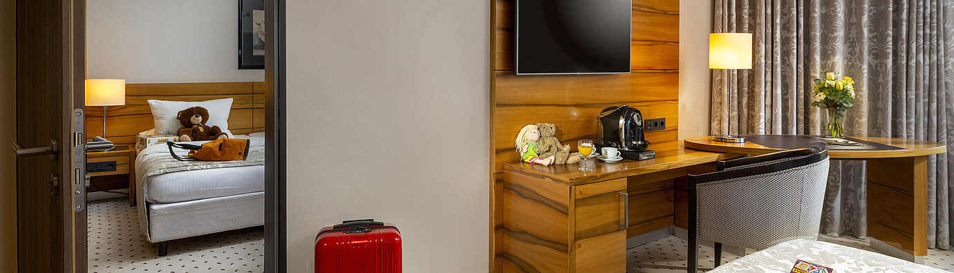 Camera di famiglia Comfort Camera familiare al Maritim Hotel Bad Homburg con stanza separata per bambini, orsacchiotti e valigia rossa