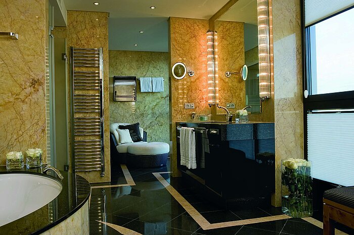 Salle de bain luxueuse de la suite présidentielle de l'hôtel Maritim de Düsseldorf avec murs en marbre, équipement moderne.