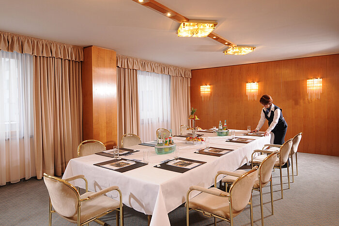 Sala de conferencias elegante en el Hotel Maritim Magdeburgo con mesa puesta y servicio.