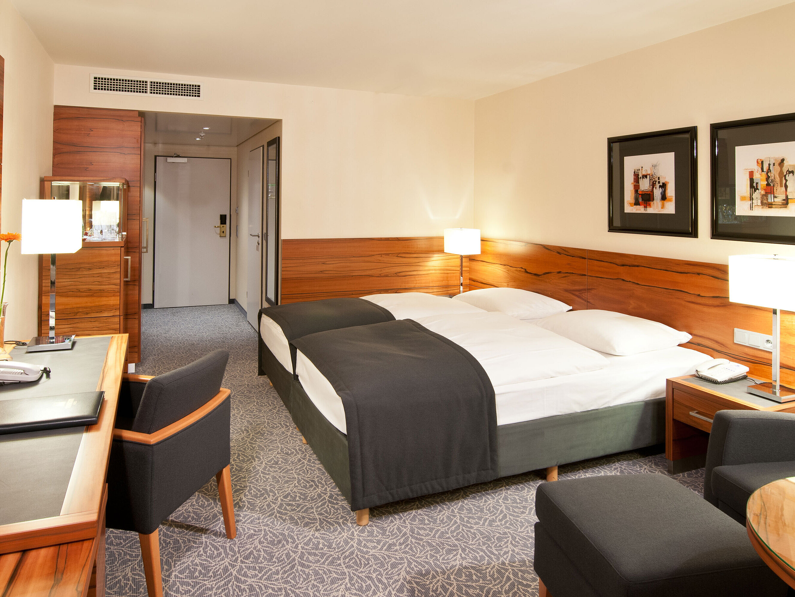 Chambre double avec bois, coin salon et bureau à l’hôtel Maritim Munich