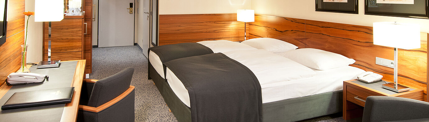 Chambre double avec bois, coin salon et bureau à l’hôtel Maritim Munich