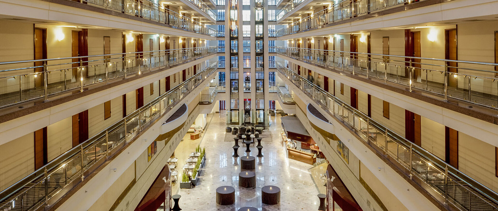 Lobby Impressive hotel lobby with glass ceiling, multiple floors, and seating areas, creating a spacious and elegant ambiance