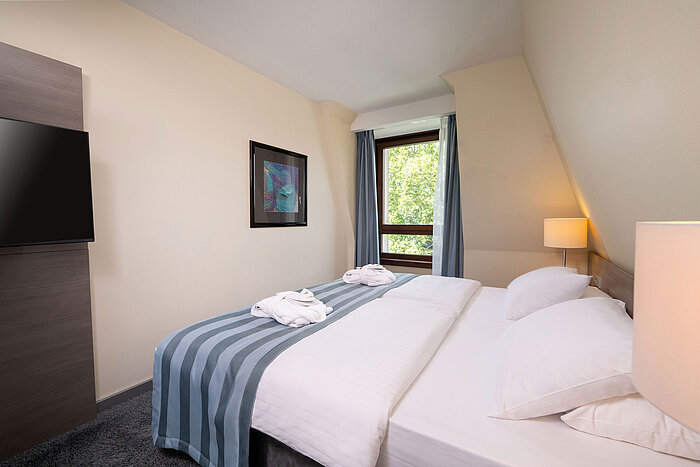 Suite Junior Dormitorio de la Suite Junior del Maritim Hotel Königswinter con cama doble, ventana y ambiente luminoso.