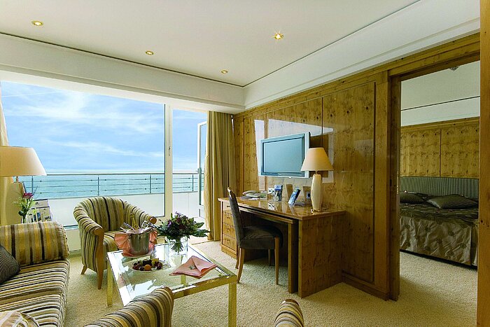 Suite penthouse au Maritim Seehotel Timmendorfer Strand avec vue sur la mer, salon et chambre séparée.