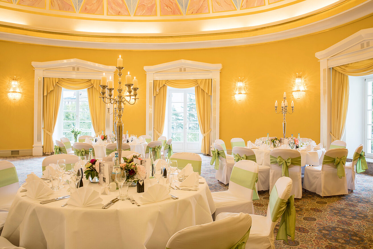 Sala da banchetto con coperture bianche e fiocchi verdi per matrimoni al Maritim Hotel Bad Wildungen