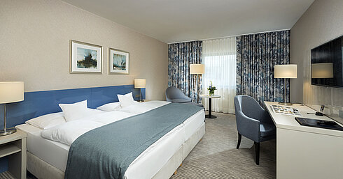 Chambre supérieure à l'hôtel Maritim Bonn avec un design élégant, des lits confortables et un coin bureau moderne.