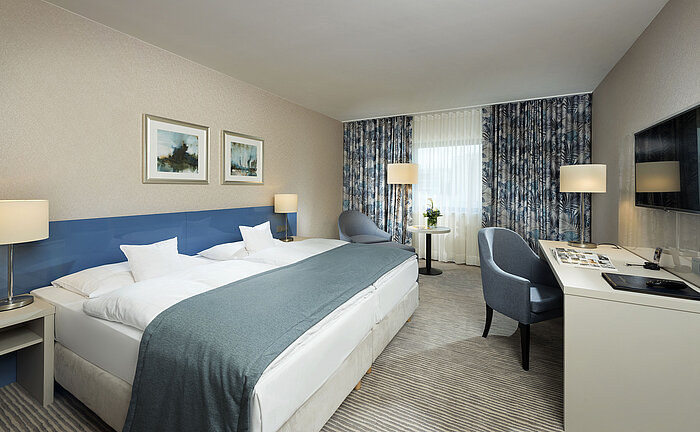 Camera Superior al Maritim Hotel Bonn con design elegante, letti comodi, scrivania moderna e area salotto confortevole.