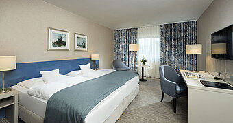 Habitación Superior en el Hotel Maritim Bonn con diseño elegante, camas cómodas, escritorio moderno y acogedora zona de estar.