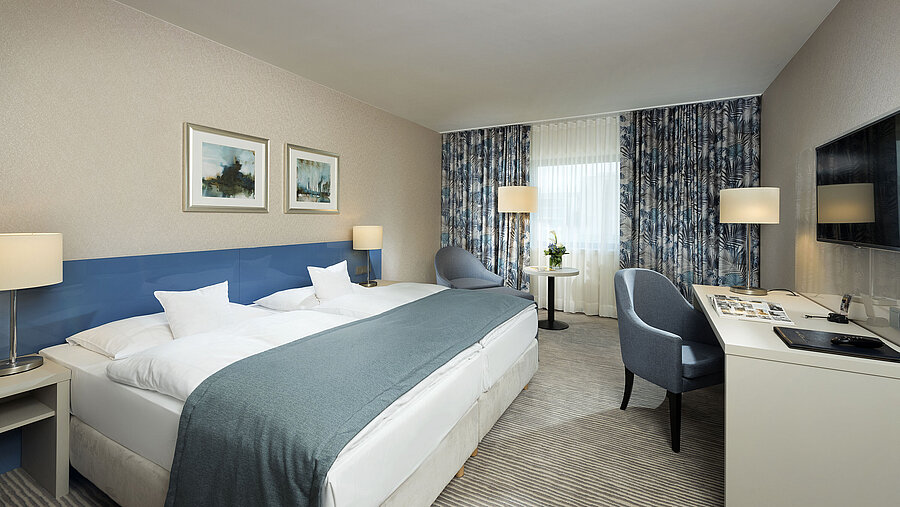 Chambre supérieure à l'hôtel Maritim Bonn avec un design élégant, des lits confortables et un coin bureau moderne.