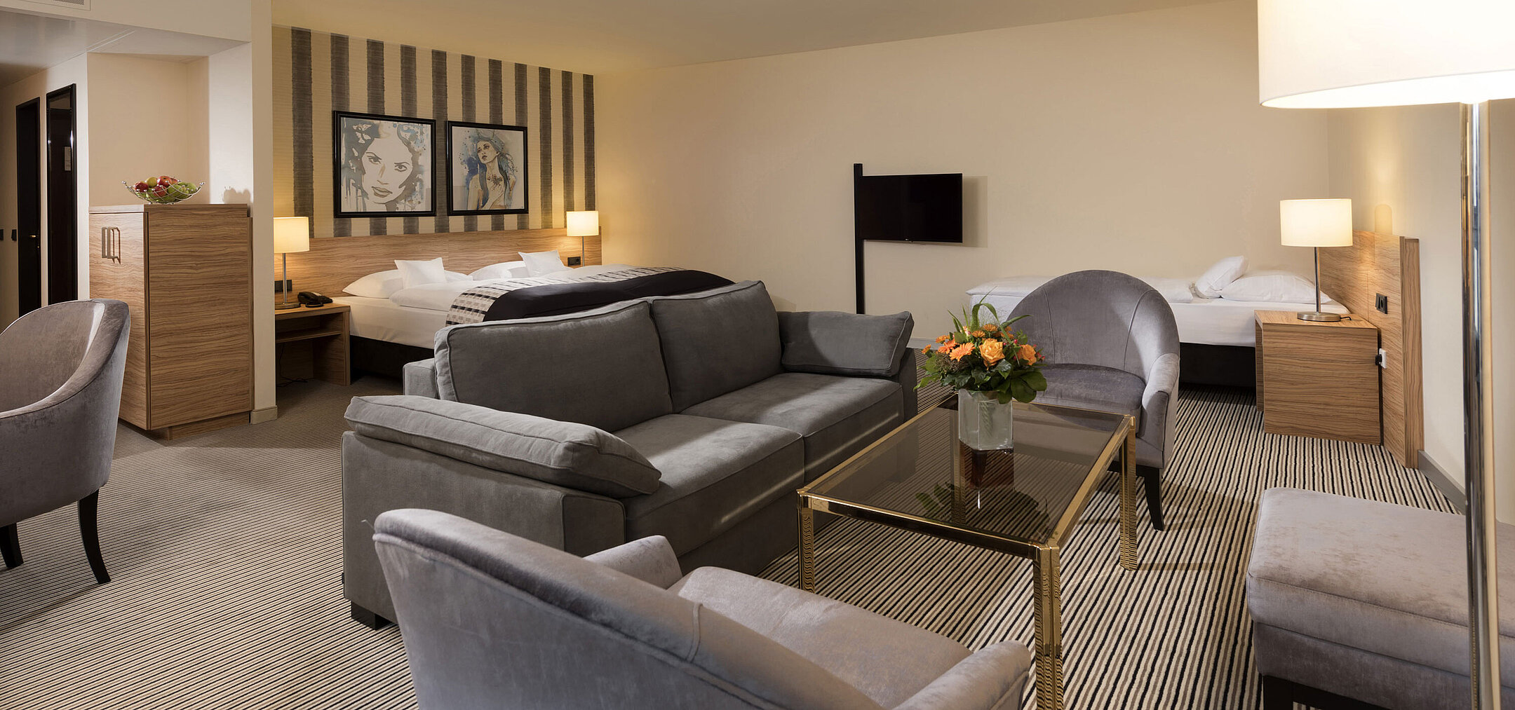 Suite spacieuse de l'hôtel Maritim Königswinter avec coin salon et design élégant.
