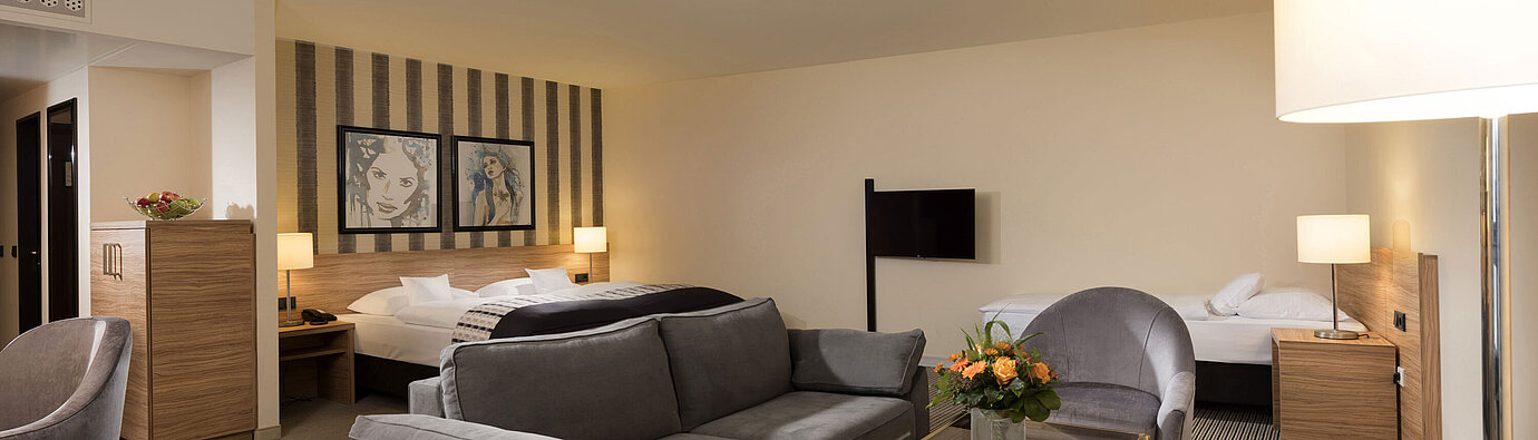 Chambre familiale du Maritim Hotel Königswinter avec coin salon et design élégant.