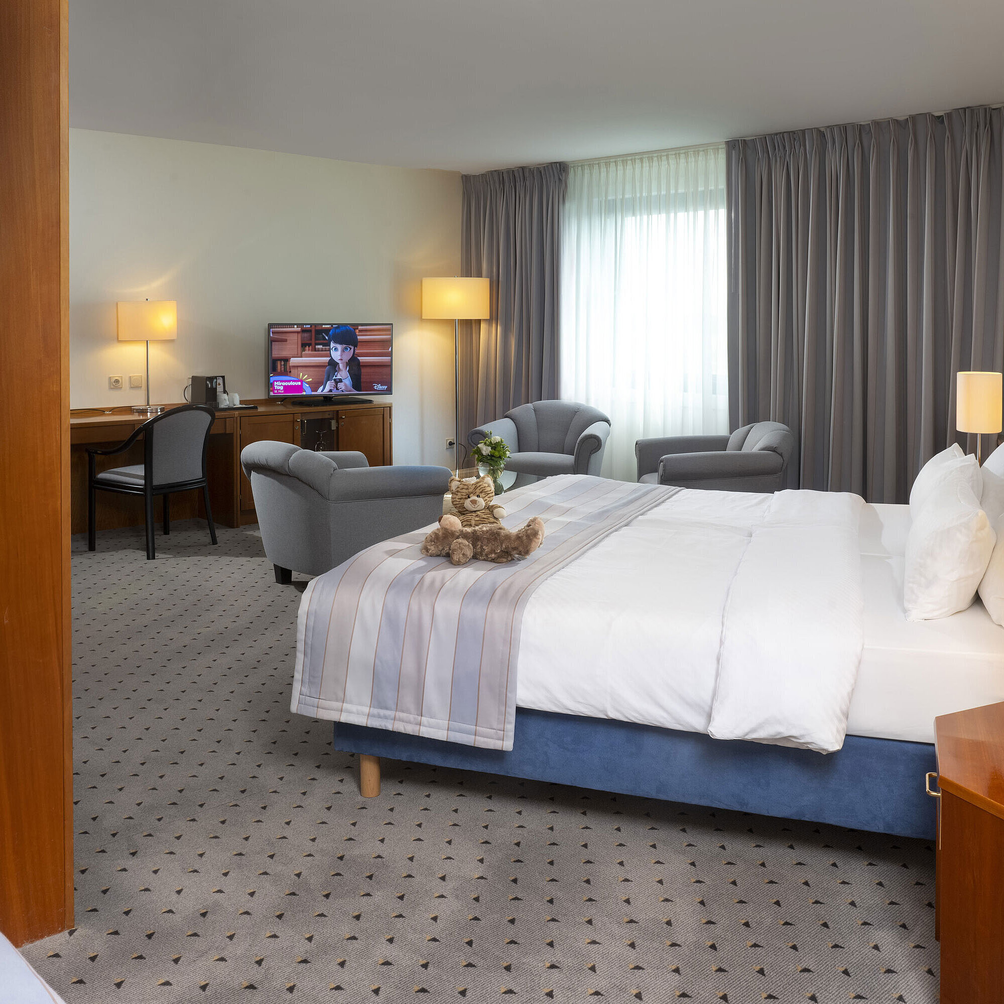 Camera di famiglia Superior Camera spaziosa al Maritim Hotel Hannover con letto matrimoniale, area salotto e TV.