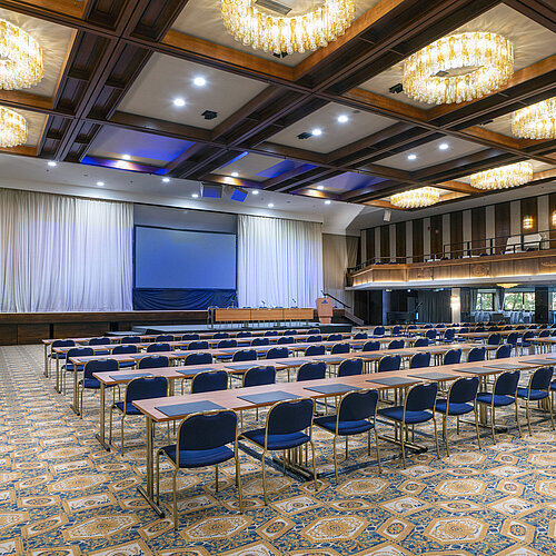 Salle spacieuse avec scène, écran et rangées de sièges à l’hôtel Maritim Travemünde
