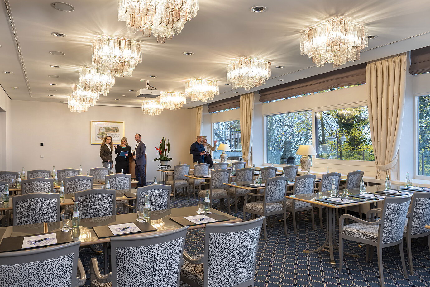 El Salón Copenhague del Maritim Hotel Kiel es una elegante sala de conferencias con lámparas de araña, mesas tendidas y grandes ventanales.