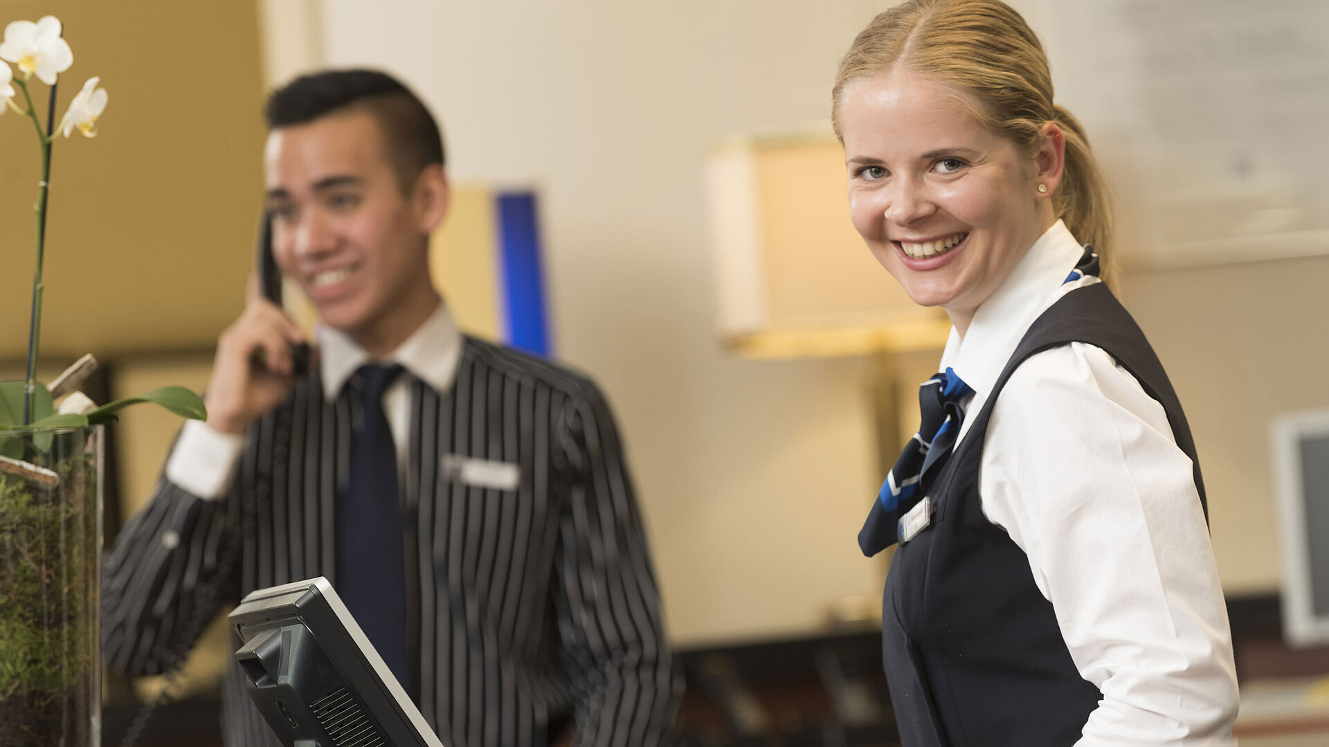 Personnel souriant à la réception de l'hôtel Maritim Bad Homburg offrant un accueil chaleureux.