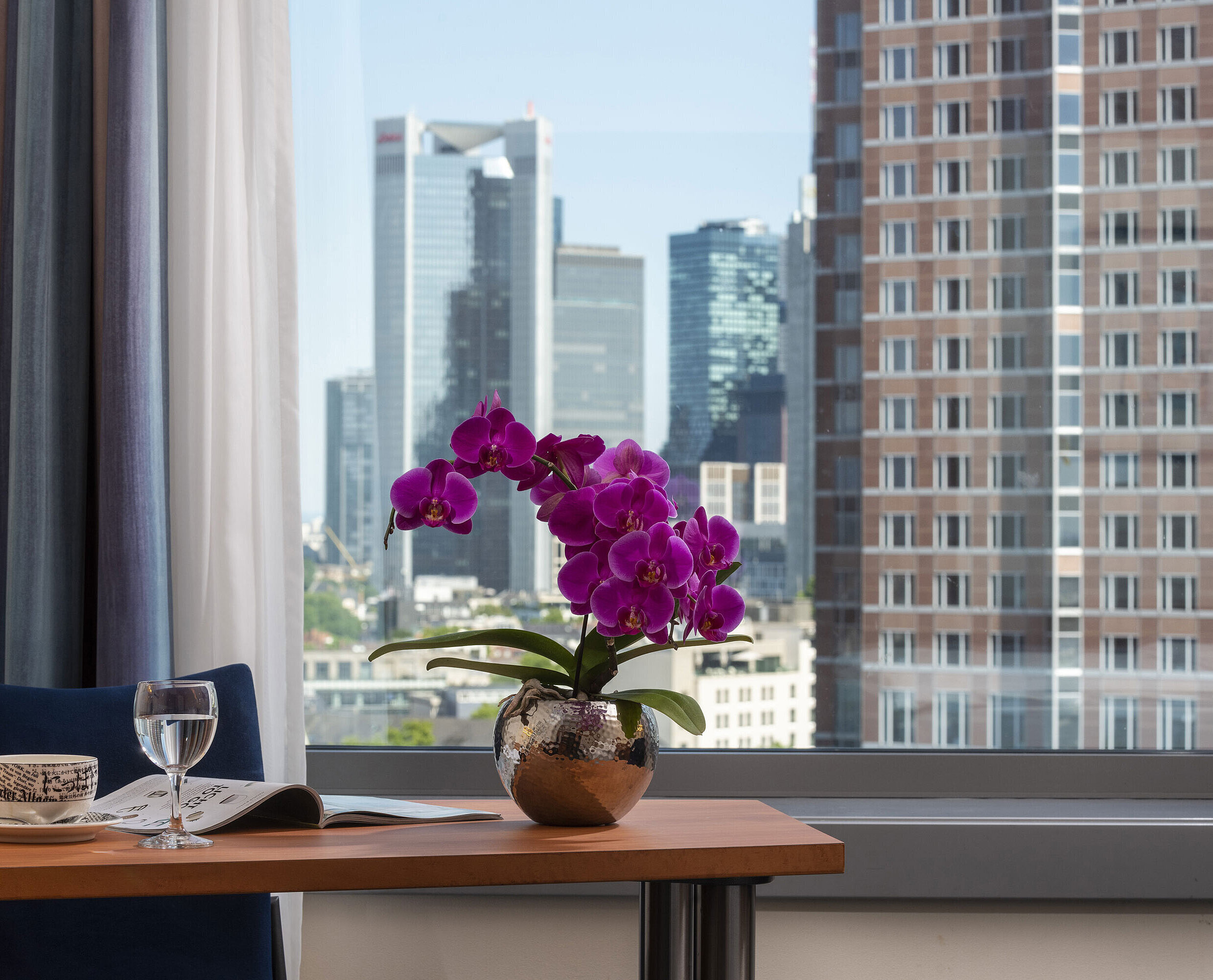 Camera Superior Skyline Vista dalla camera del Maritim Hotel Frankfurt con panorama skyline, scrivania e orchidea elegante.