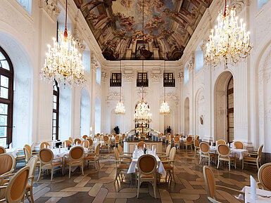 Elegante Salón Apollo en Maritim Hotel Fulda con lámparas, techo con frescos y mesas sofisticadas.
