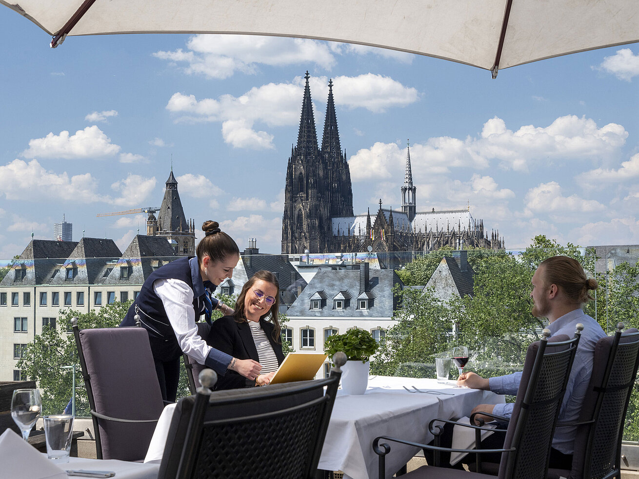 Rooftop terrace Guests enjoying service on the rooftop terrace of Maritim Hotel Cologne with views of Cologne Cathedral and the Old Town.