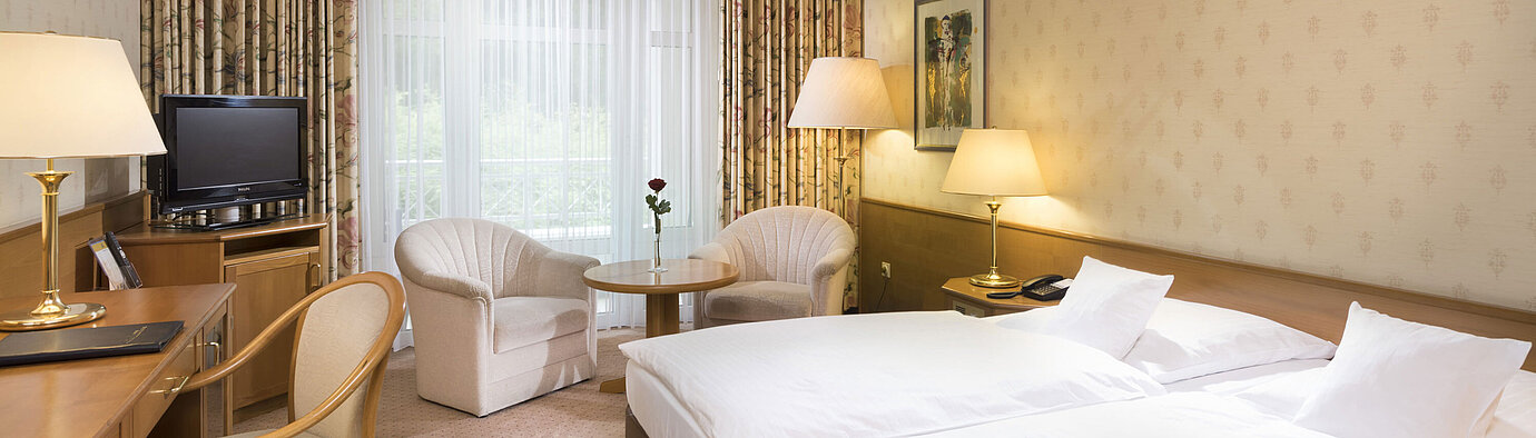 Chambre double lumineuse avec coin salon et bureau au Maritim Hotel Bad Wildungen