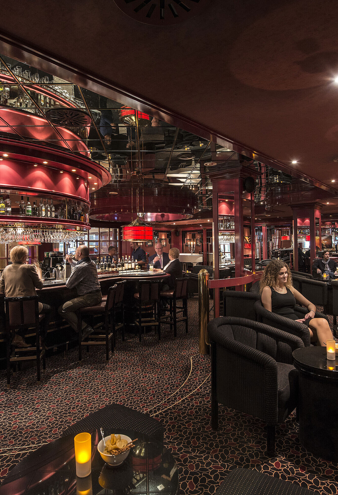 Guests enjoying drinks in stylish red-lit hotel bar at Maritim Hotel Stuttgart
