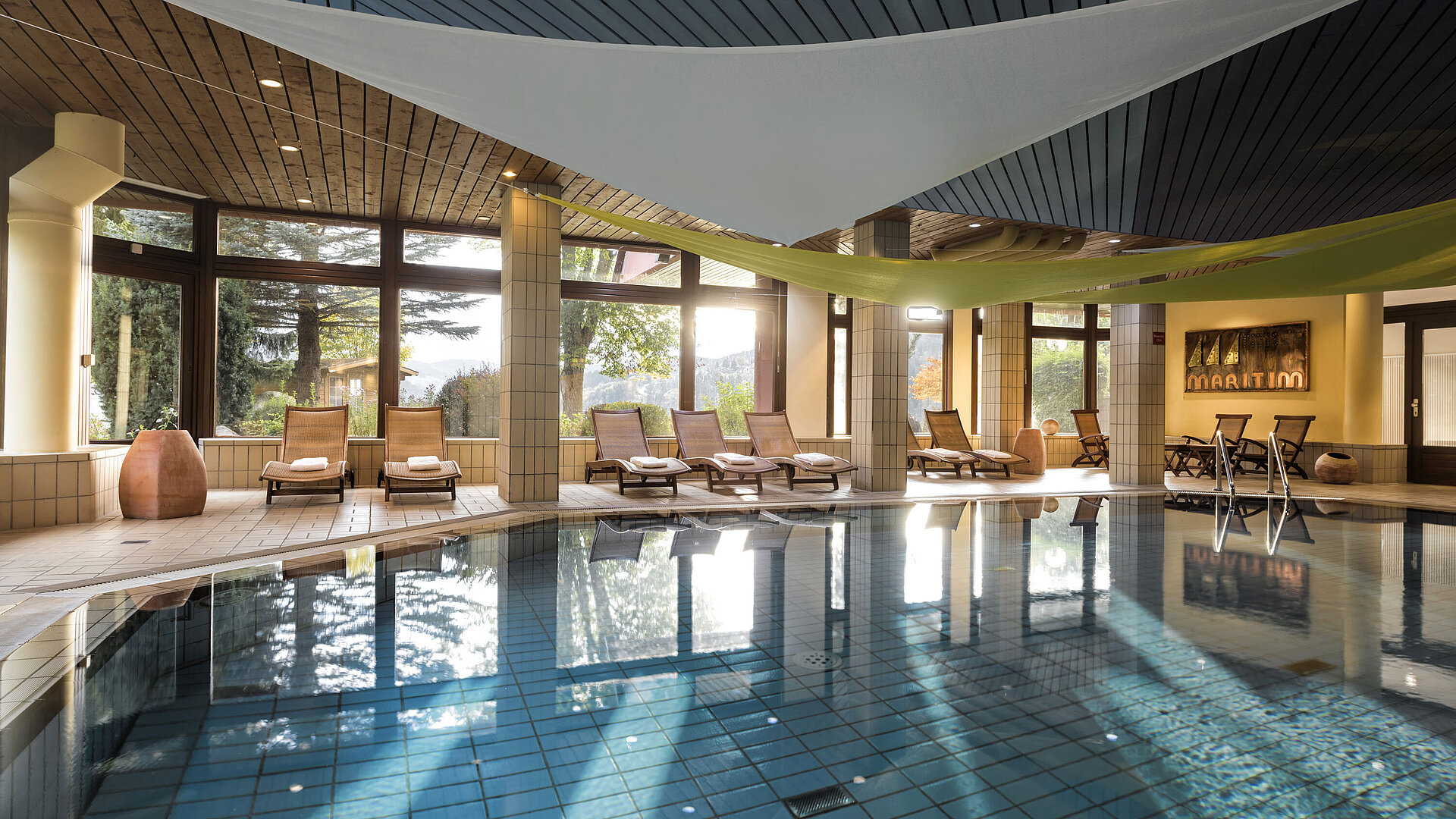 Pool Bright indoor pool with loungers and garden view at the Maritim Hotel Titisee