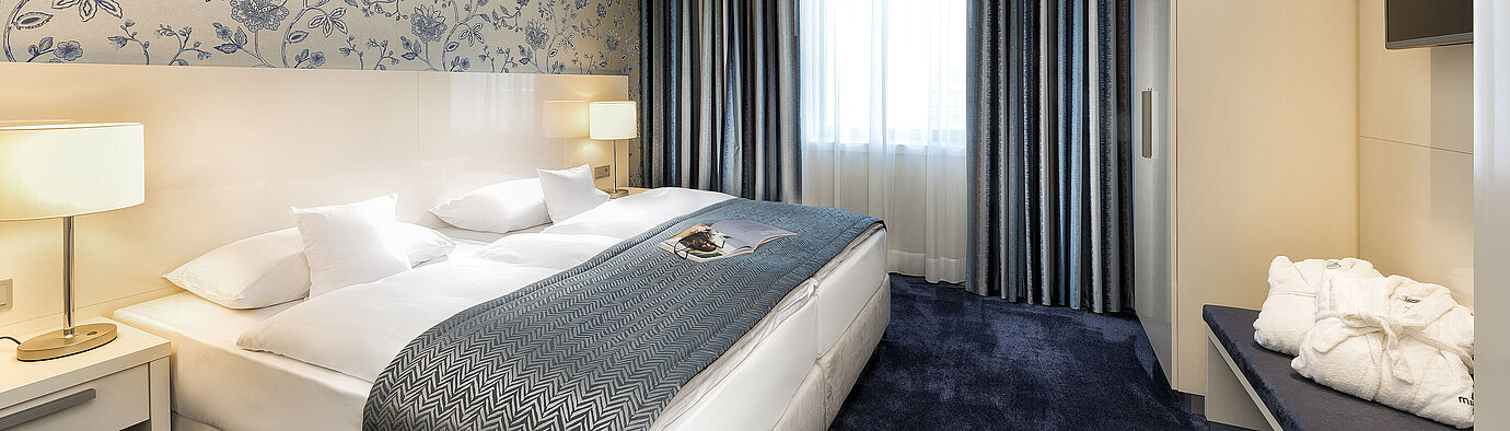 Panorama suite  Elegant suite at Maritim Hotel Bonn with a large bed, blue bedspread, and stylish decor.