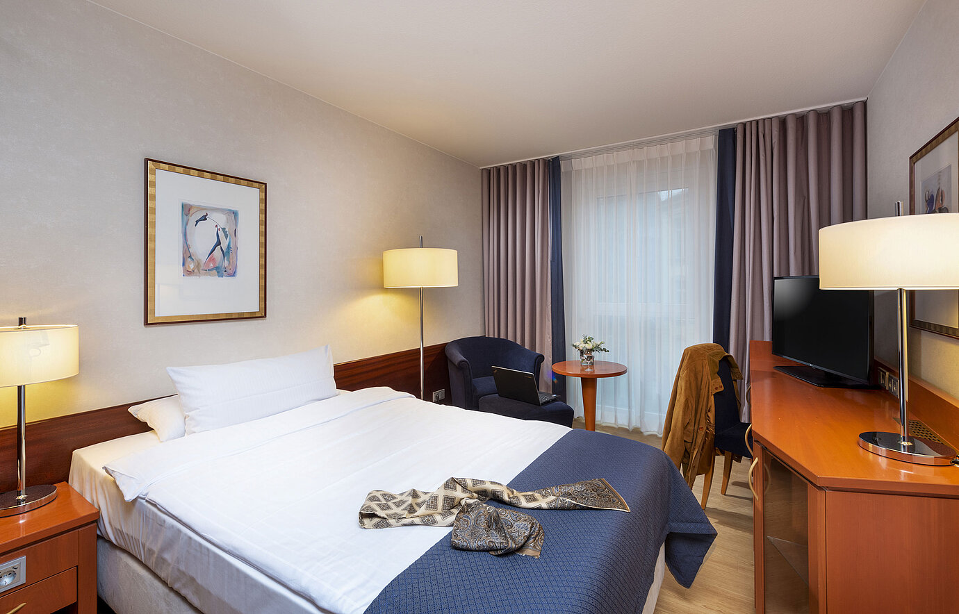 Luminosa camera singola al Maritim Hotel Würzburg con area salotto e guardaroba moderno